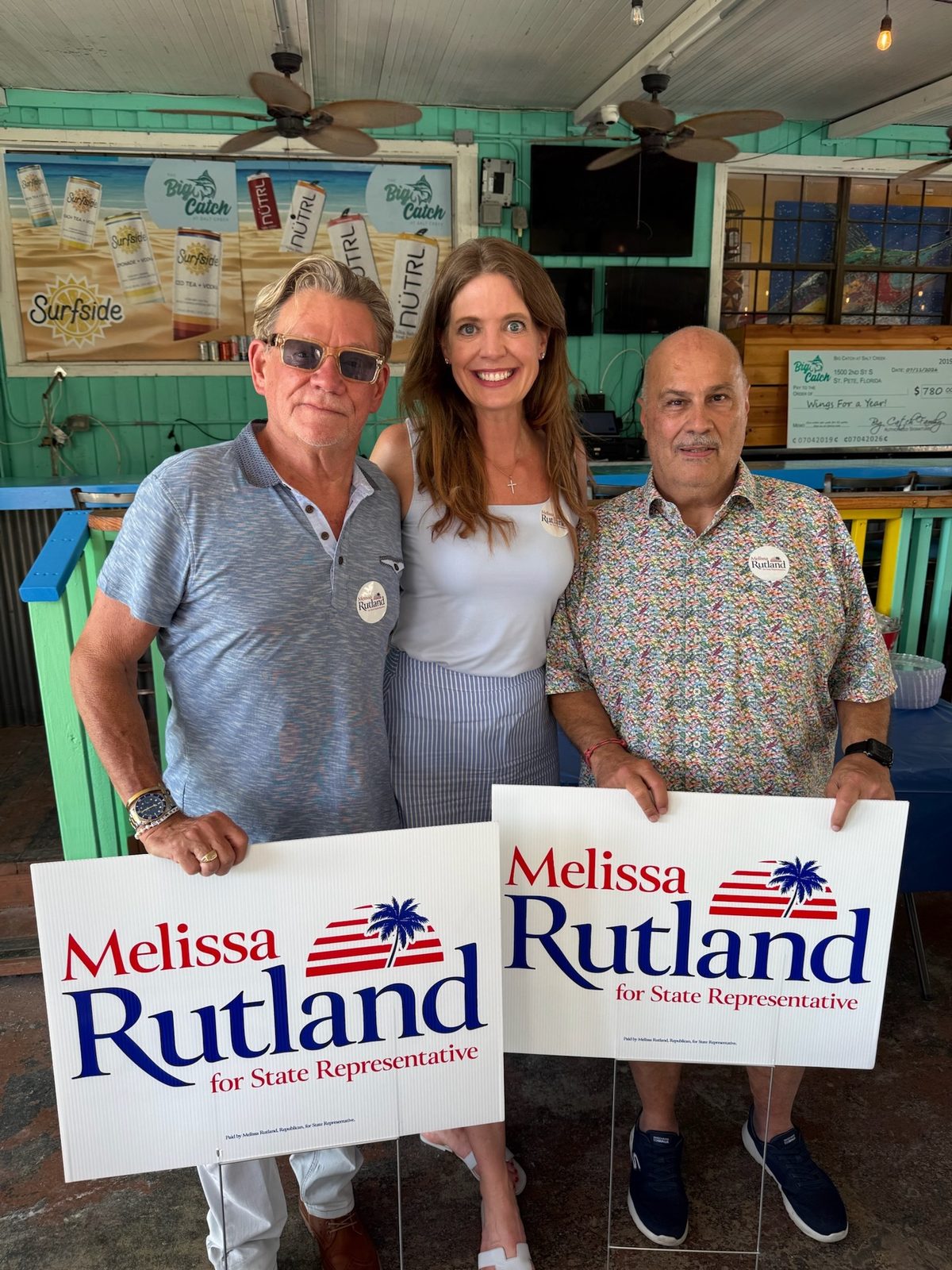 Melissa Rutland with supporters holding Melissa Rutland yard signs in St. Petersburg
